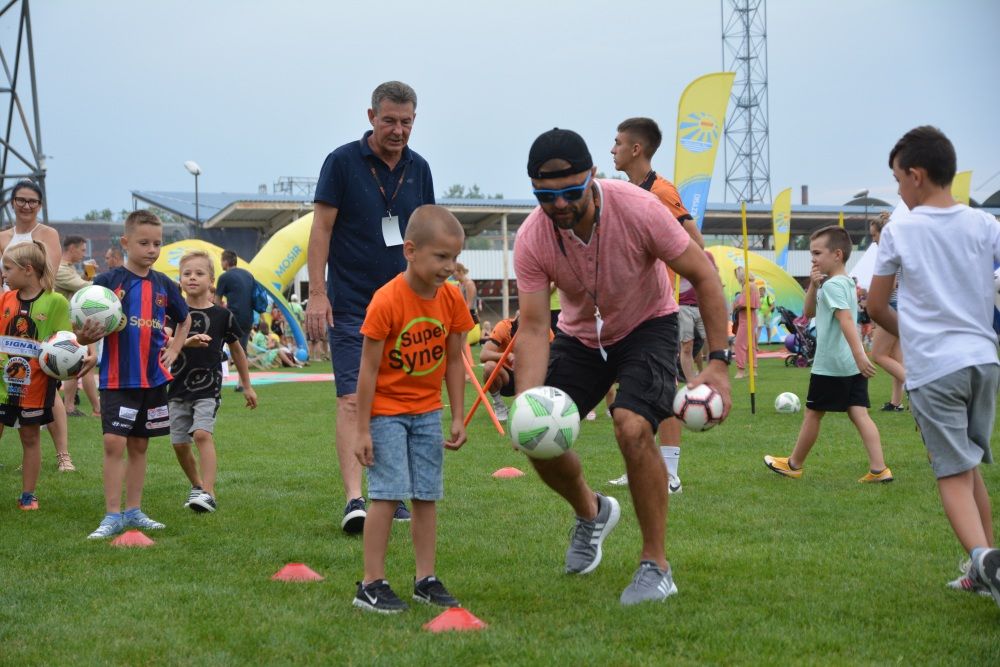 Trenerzy piłki nożnej prowadzą pokazowy trening z dziećmi